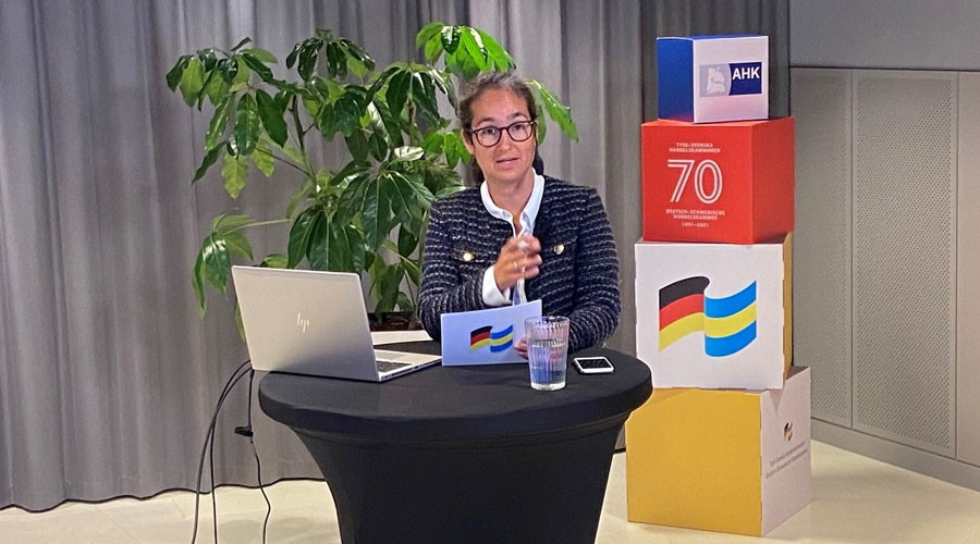 Verena Adamheit standing at a high table with a laptop. Photo.