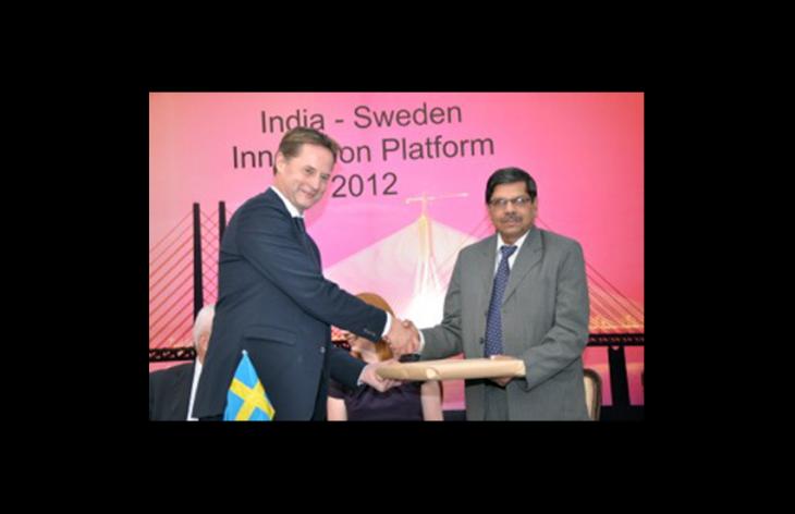 An Indian and a Swedish man shaking hands. Photo.