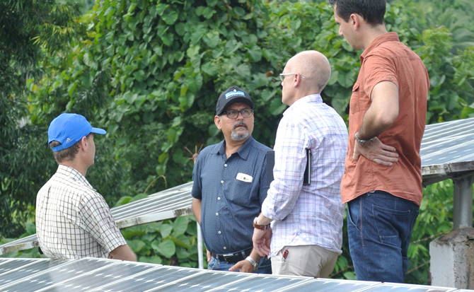 Business people inspecting solar panels outdoors.