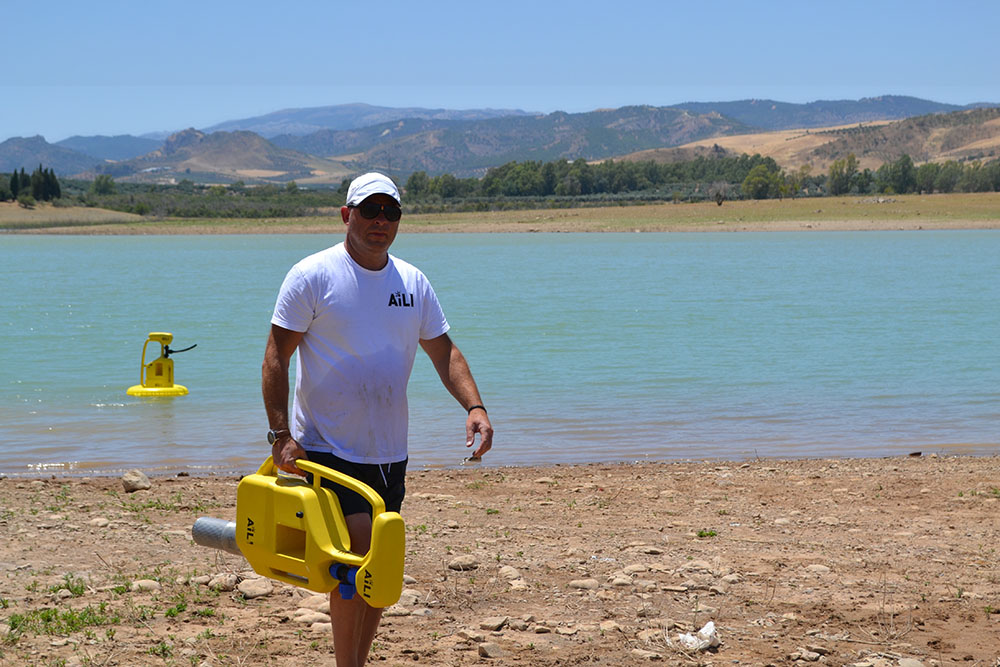 Henrik Johansson carrying a yellow water pump. Photo.