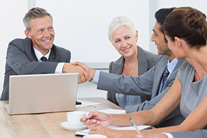 Four business people at a table. Photo.