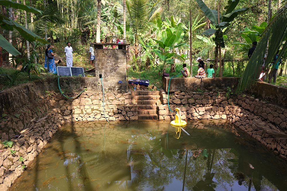 Yellow water pump in a small pond. Photo.